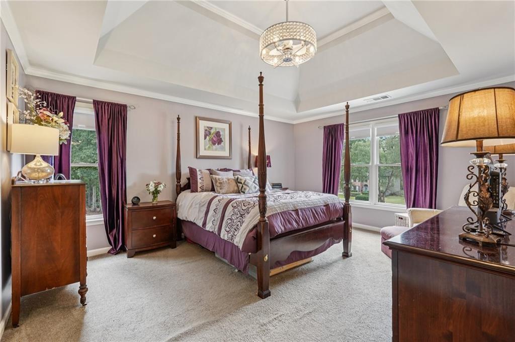 3820 Ridge Point Drive Suwanee, GA 30024 - Photo 25 of 41 a spacious bedroom with a bed and a chandelier