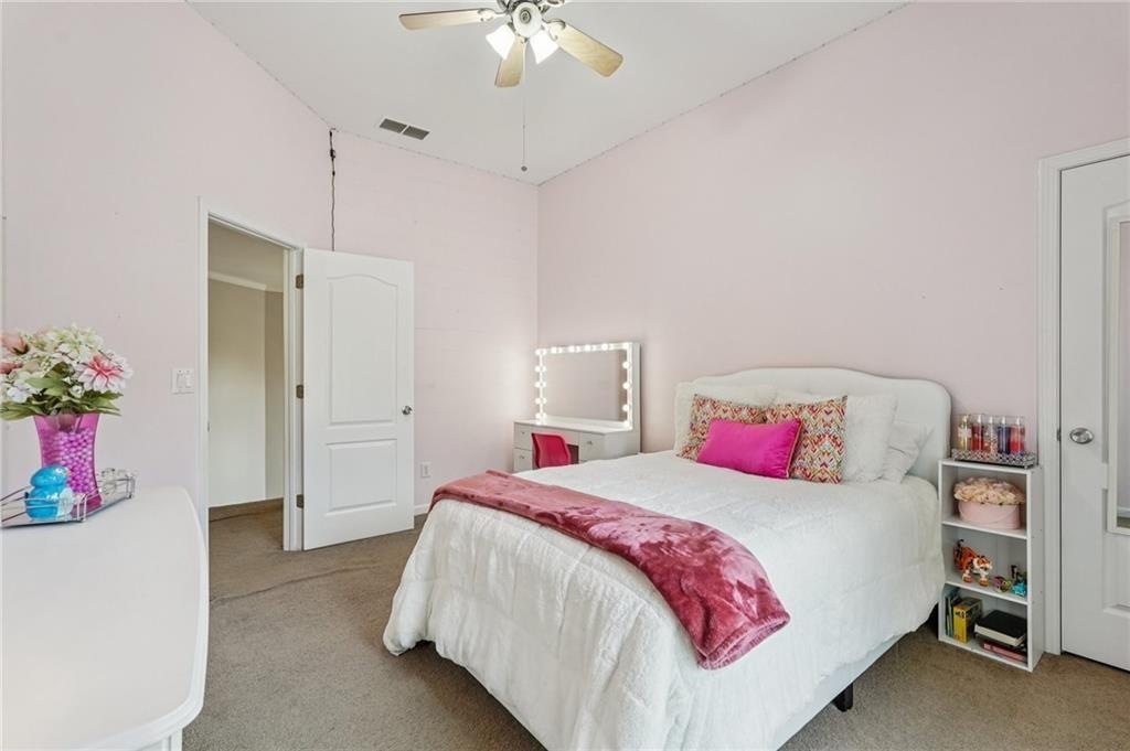 3820 Ridge Point Drive Suwanee, GA 30024 - Photo 32 of 41 a bedroom with a bed and a chandelier