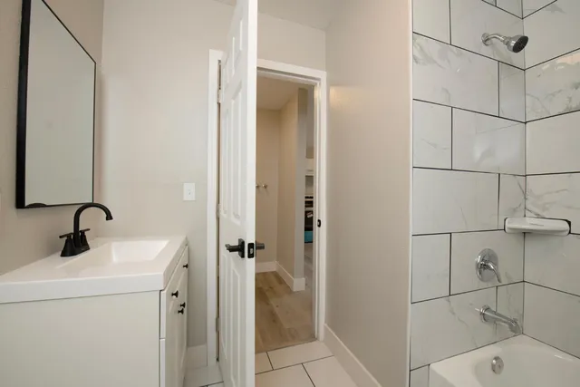a bathroom with a sink a light fixture and a mirror