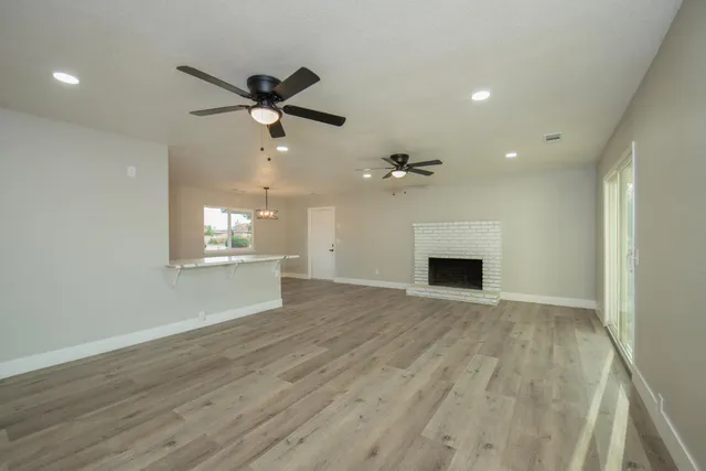 a view of an empty room with a fireplace and a window