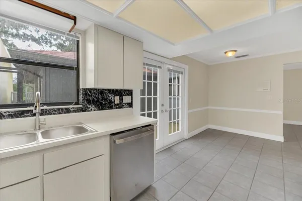 a kitchen with a sink white cabinets and white appliances