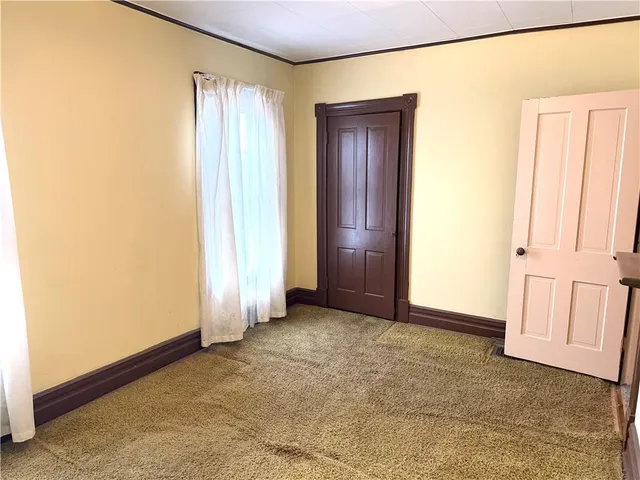 a view of an empty room with a glass door and a window