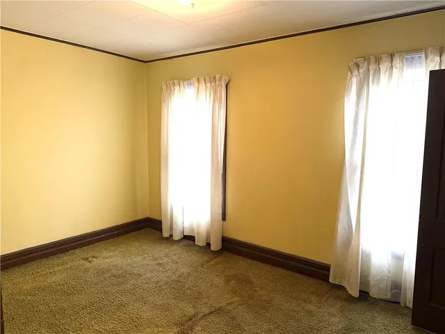 a view of an empty room with closet and entryway