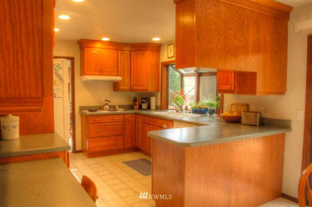 18731 129th Court Northeast Bothell, WA 98011 - Photo 6 of 24 a kitchen with stainless steel appliances granite countertop a sink a stove and a refrigerator