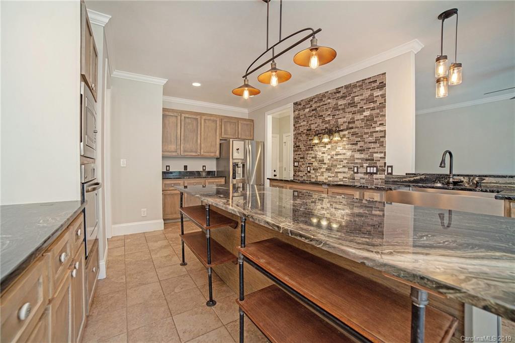 5415 Unionville Road Monroe, NC 28110 - Photo 10 of 40 a kitchen with stainless steel appliances granite countertop a sink a stove and a wooden cabinets