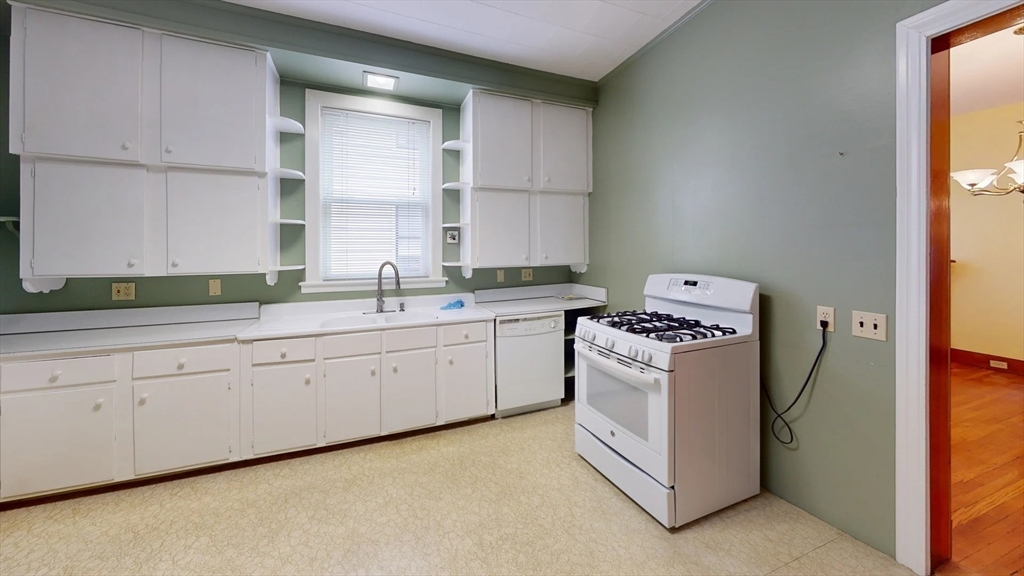 a kitchen with cabinets appliances a sink and a window