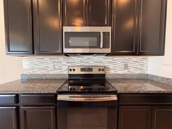 a stove top oven sitting inside of a kitchen