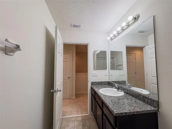 a bathroom with a granite countertop sink and a mirror