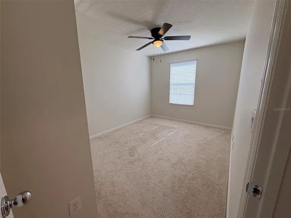 a view of room with a ceiling fan and window