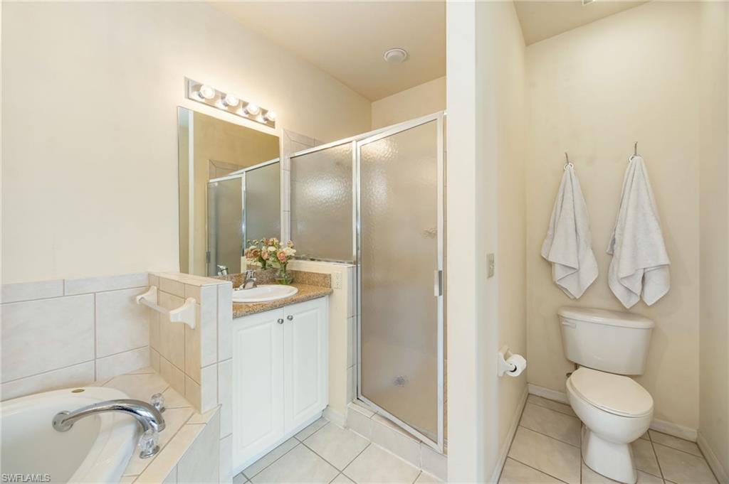 7920 Mahogany Run Lane, Unit 1024 Naples, FL 34113 - Photo 18 of 28 Retreat to the bright and inviting primary suite, where expansive windows fill the space with natural light. Featuring two walk-in closets and direct lanai access, this serene sanctuary overlooks the sparkling pool and tranquil water feature, creating the perfect setting to relax and unwind.