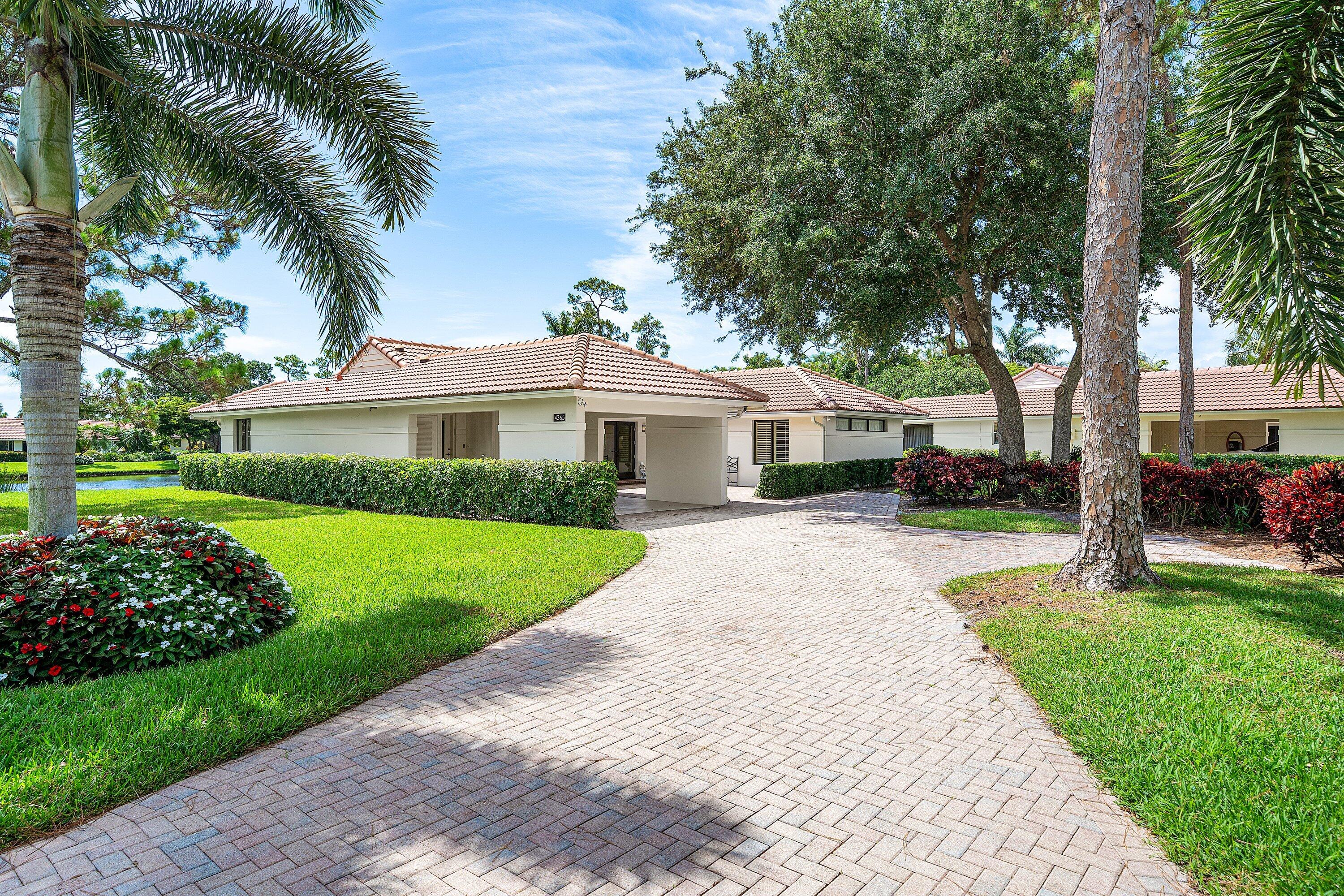 4365 Shell Drake Lane Boynton Beach, FL 33436 - Photo 46 of 56 a front view of a house with a garden and trees