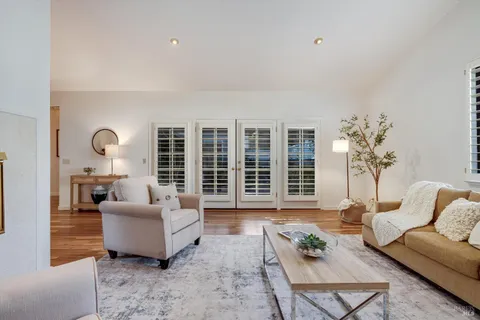 a living room with furniture a fireplace and wooden floor