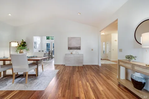 a kitchen with a table chairs a sink dishwasher refrigerator and cabinets