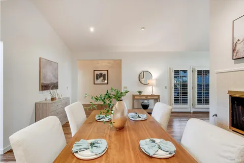 a kitchen with stainless steel appliances kitchen island granite countertop a dining table chairs and refrigerator