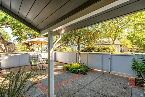 a view of patio with a table and chairs and potted plants