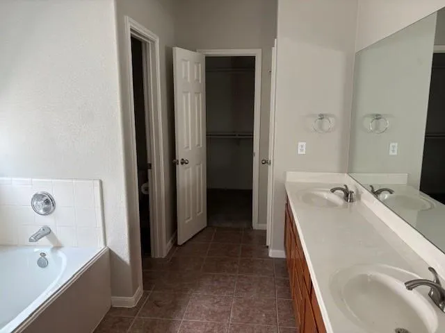 a bathroom with a tub sink and mirror