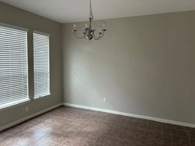 en empty room with windows and chandelier fan