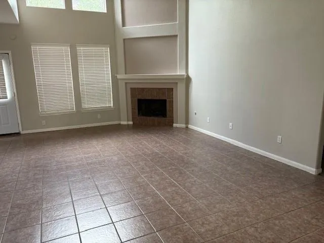 a view of an empty room with a fireplace and a window