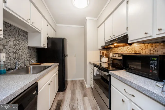 a kitchen with granite countertop a stove microwave and sink