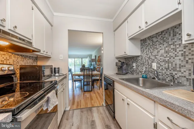 a kitchen with a sink and wooden floor