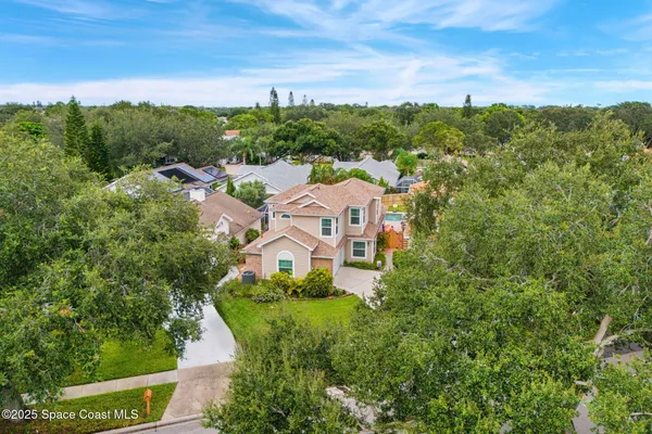 an aerial view of a house with trees all around