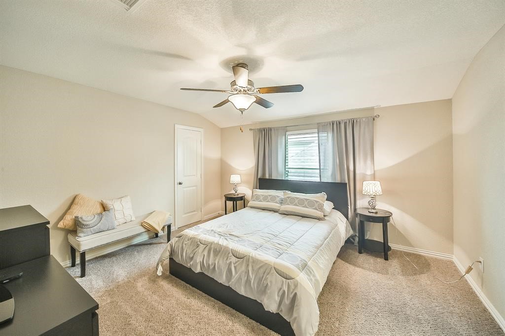 8510 Brinklow Point Drive Cypress, TX 77433 - Photo 20 of 46 a spacious bedroom with a bed and a chandelier
