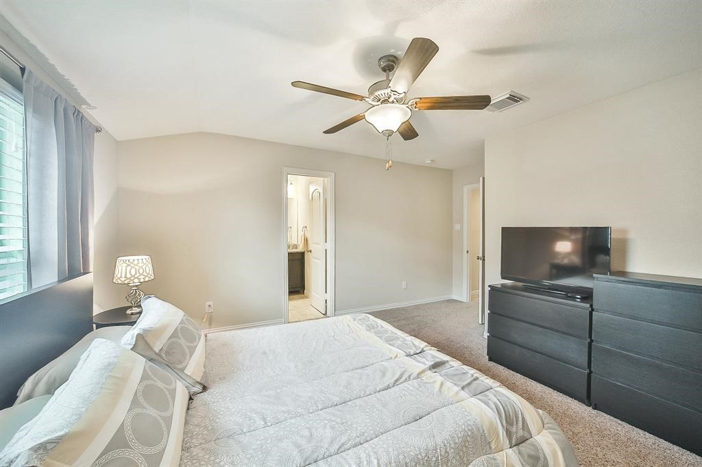 8510 Brinklow Point Drive Cypress, TX 77433 - Photo 21 of 46 a bedroom with a bed and a flat screen tv