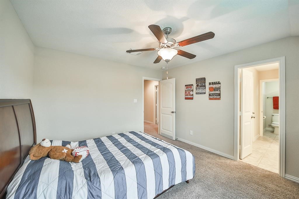 8510 Brinklow Point Drive Cypress, TX 77433 - Photo 24 of 46 a bedroom with a bed and a chandelier