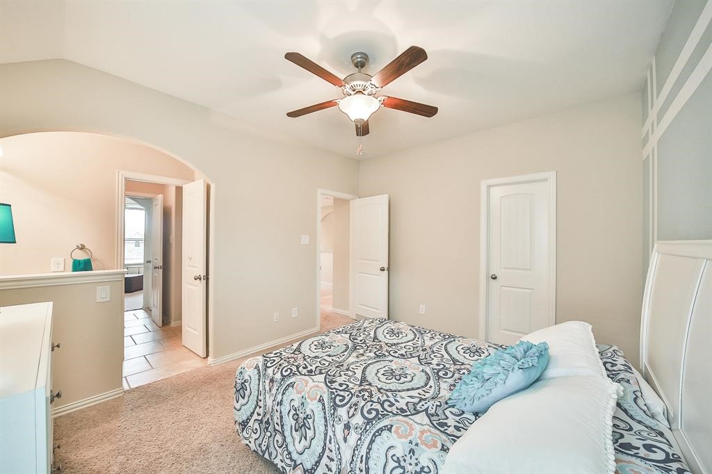 8510 Brinklow Point Drive Cypress, TX 77433 - Photo 29 of 46 a bedroom with a bed and a chandelier