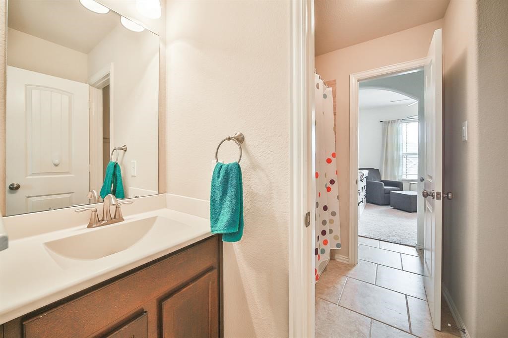 8510 Brinklow Point Drive Cypress, TX 77433 - Photo 30 of 46 a en suite bathroom with a granite countertop sink and a mirror