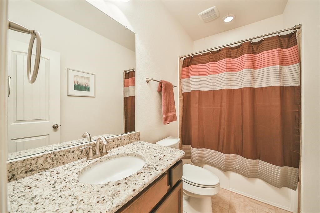 8510 Brinklow Point Drive Cypress, TX 77433 - Photo 41 of 46 a bathroom with a granite countertop sink and a mirror