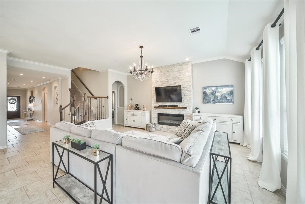 8510 Brinklow Point Drive Cypress, TX 77433 - Photo 6 of 46 a living room with furniture a fireplace and a flat screen tv
