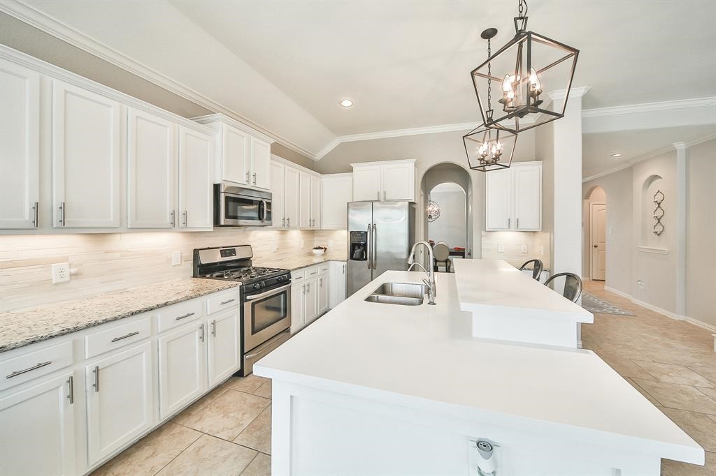 8510 Brinklow Point Drive Cypress, TX 77433 - Photo 9 of 46 a large white kitchen with stainless steel appliances granite countertop lots of white cabinets a stove top oven a sink and dishwasher
