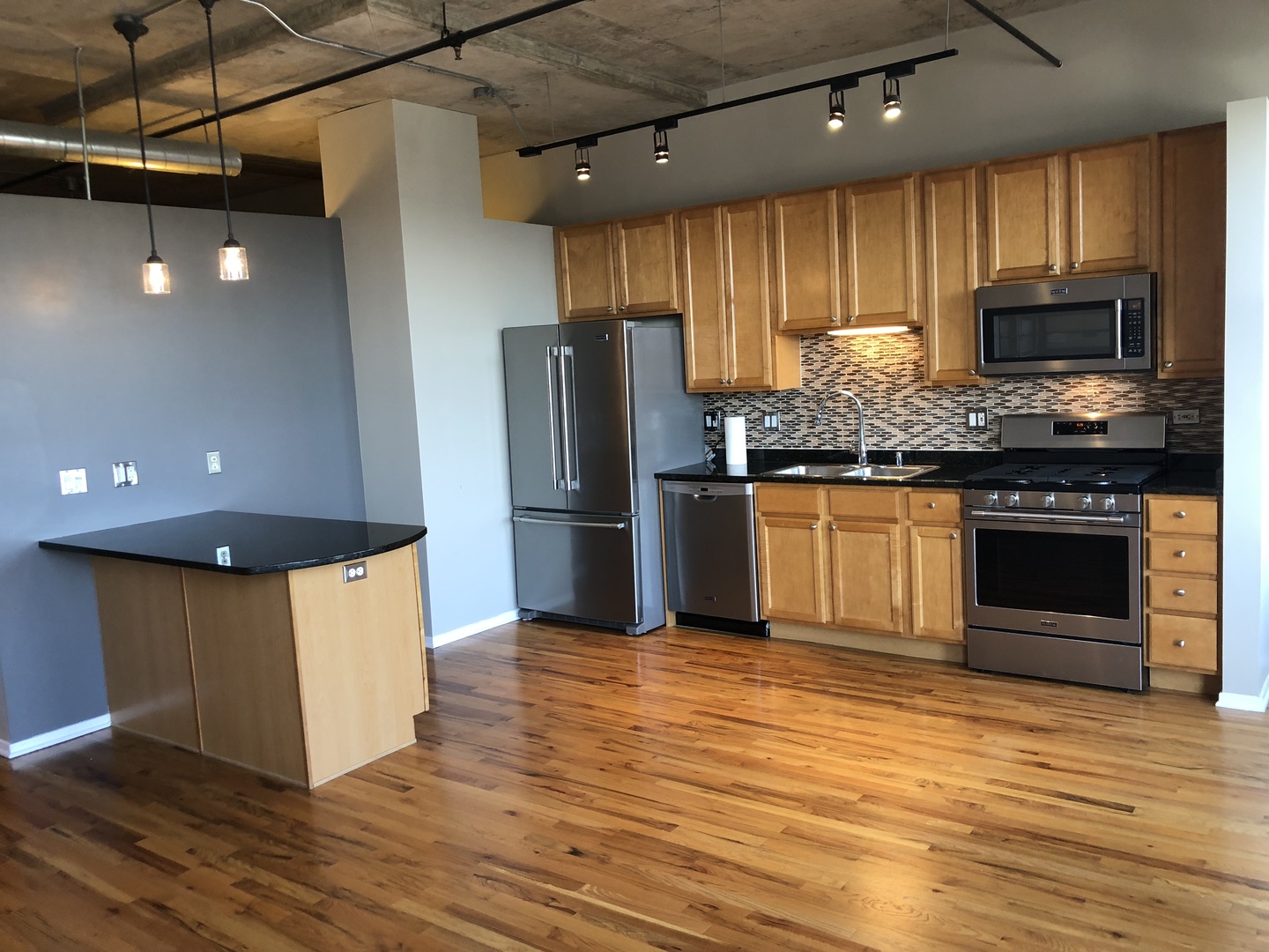 6 South Laflin Street, Unit 604 Chicago, IL 60607 - Photo 5 of 17 a kitchen with stainless steel appliances granite countertop a refrigerator a stove top oven a sink and dishwasher with wooden floor