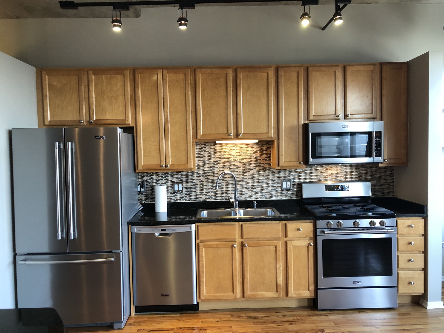 6 South Laflin Street, Unit 604 Chicago, IL 60607 - Photo 8 of 17 a kitchen with granite countertop a refrigerator stove and microwave