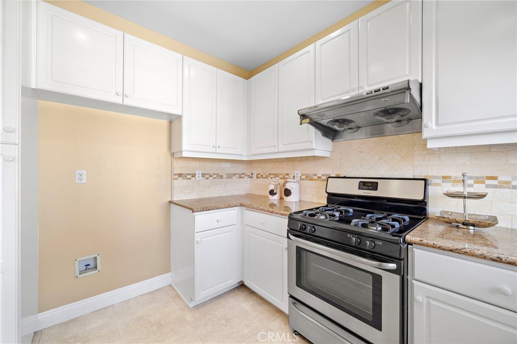 8971 Poinsettia Lane Garden Grove, CA 92841 - Photo 18 of 34 a kitchen with stainless steel appliances white cabinets and a stove a refrigerator