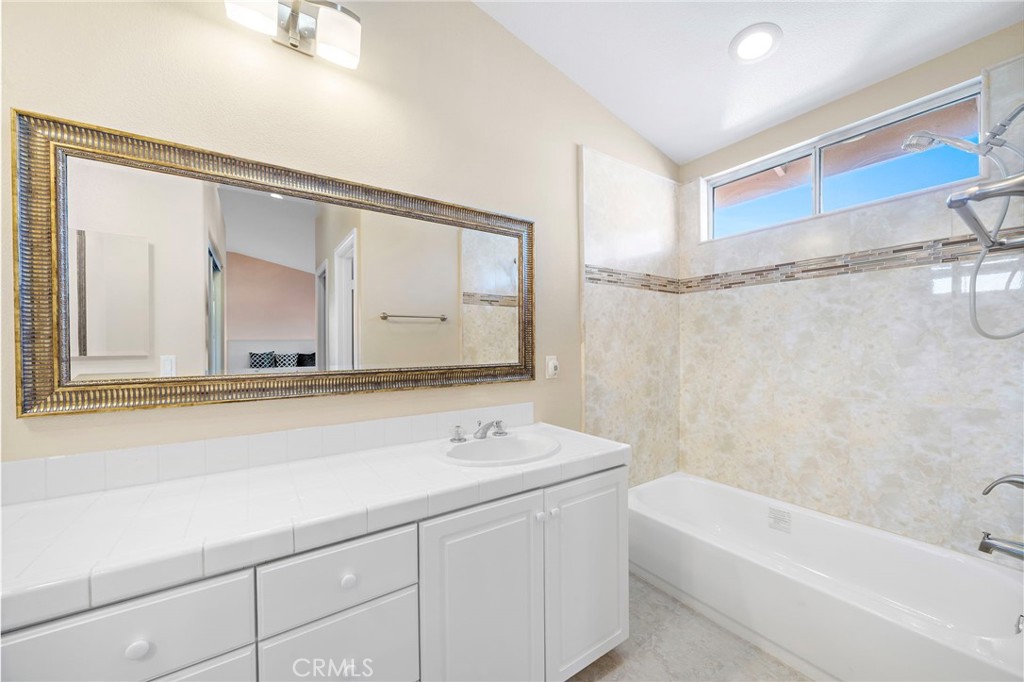 8971 Poinsettia Lane Garden Grove, CA 92841 - Photo 31 of 34 a bathroom with a tub a sink and a mirror