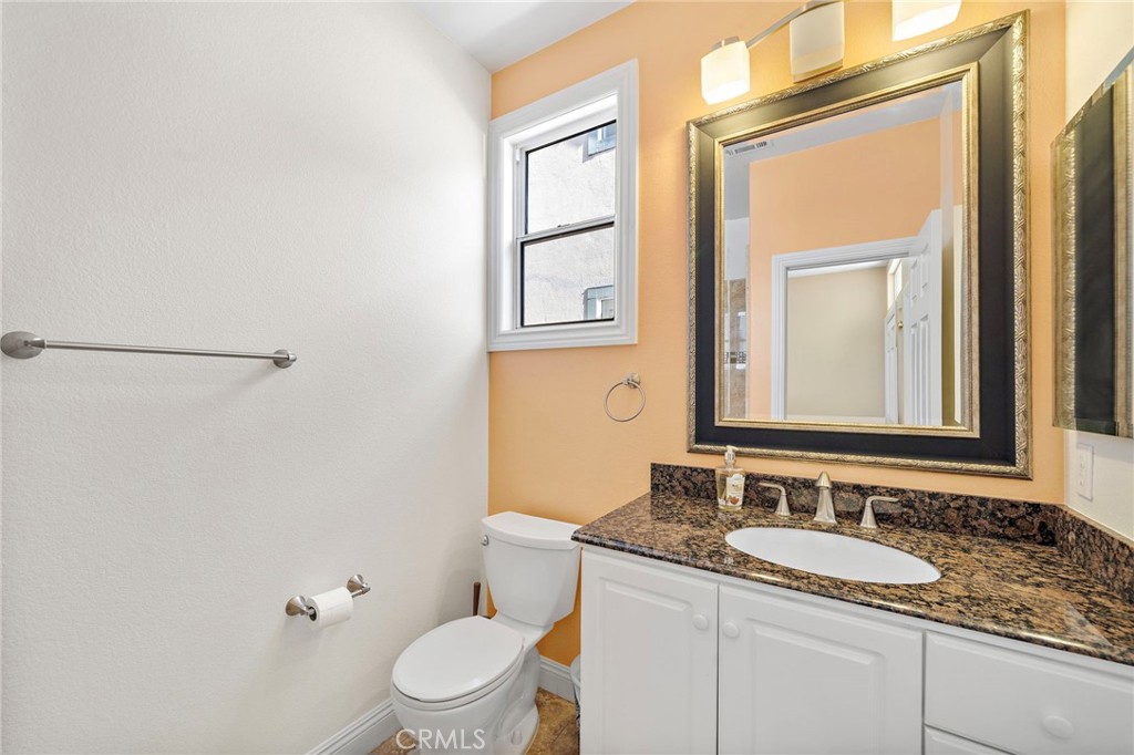 8971 Poinsettia Lane Garden Grove, CA 92841 - Photo 4 of 34 a bathroom with a granite countertop sink toilet and mirror