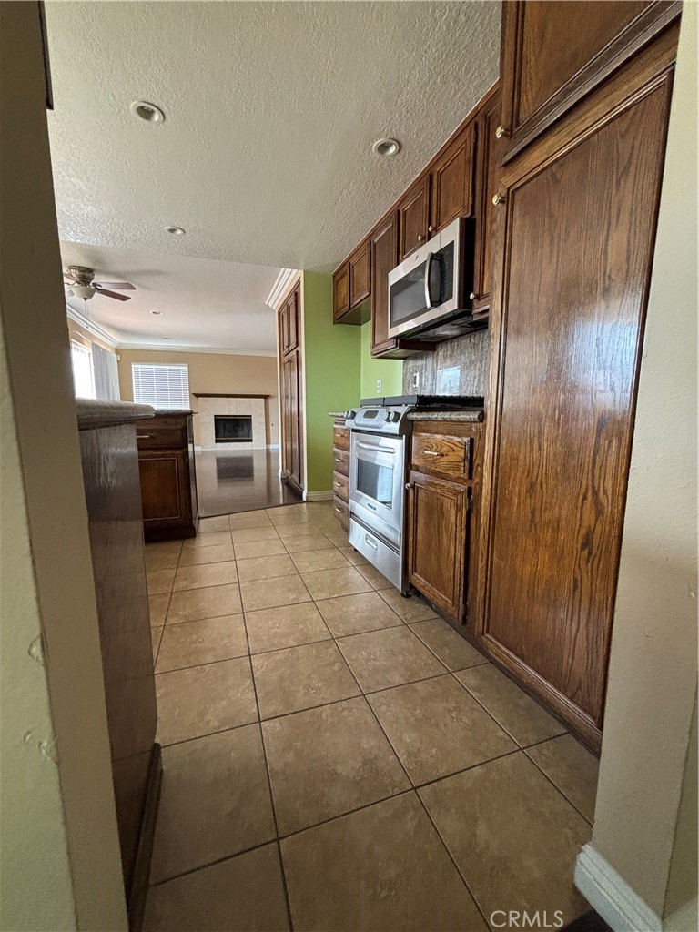 17092 Whispering Brook Way Riverside, CA 92503 - Photo 14 of 74 a kitchen with stainless steel appliances granite countertop a refrigerator and a stove top oven