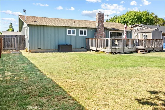 a view of a house with a yard and large tree