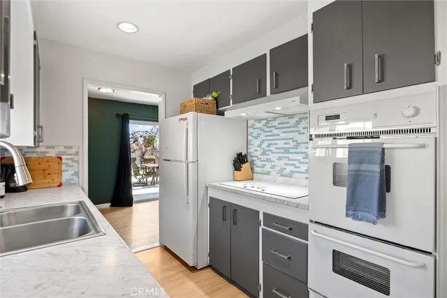 a kitchen with stainless steel appliances granite countertop a refrigerator a stove and a sink