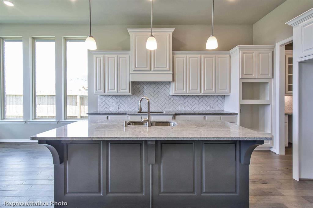 a kitchen with granite countertop a sink a window stainless steel appliances and cabinets