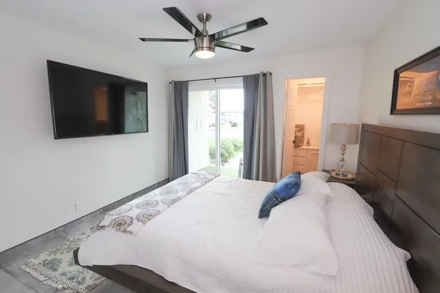 a bedroom with a large bed and a flat screen tv