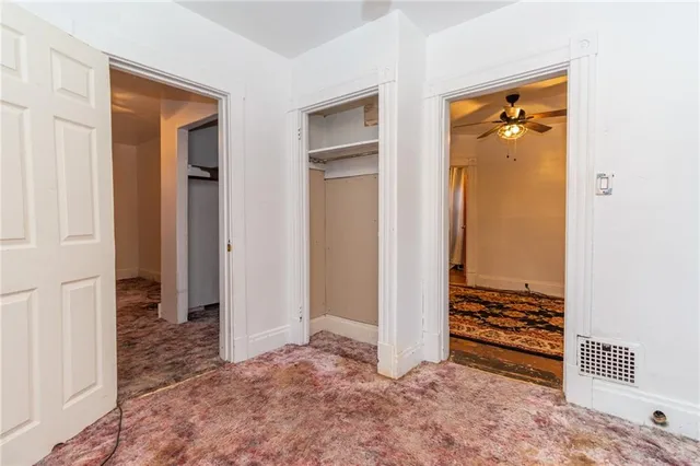 a view of room with walk in closet and wooden floor