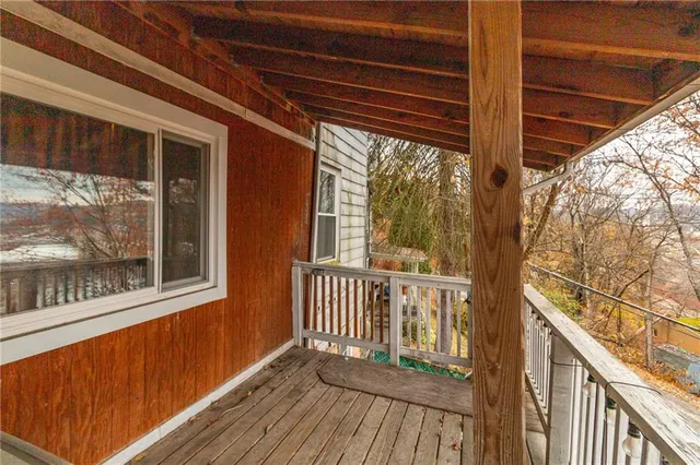 a view of a porch with wooden floor and furniture