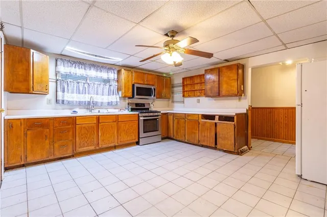 a kitchen with stainless steel appliances a sink a stove cabinets and a window