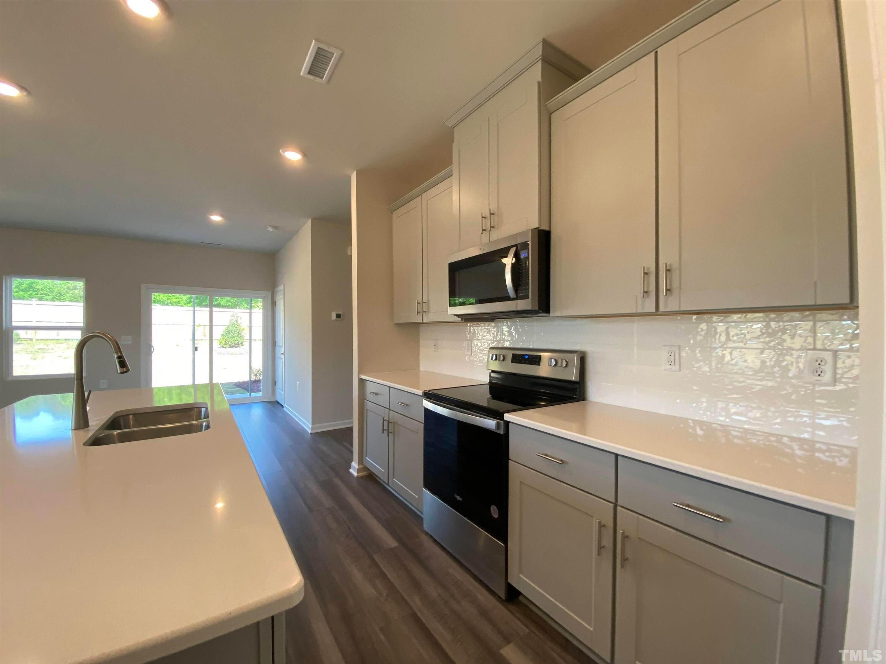 908 Clearhaven Lane Fuquay-Varina, NC 27526 - Photo 13 of 23 a kitchen with stainless steel appliances a sink a stove top oven a counter space and cabinets