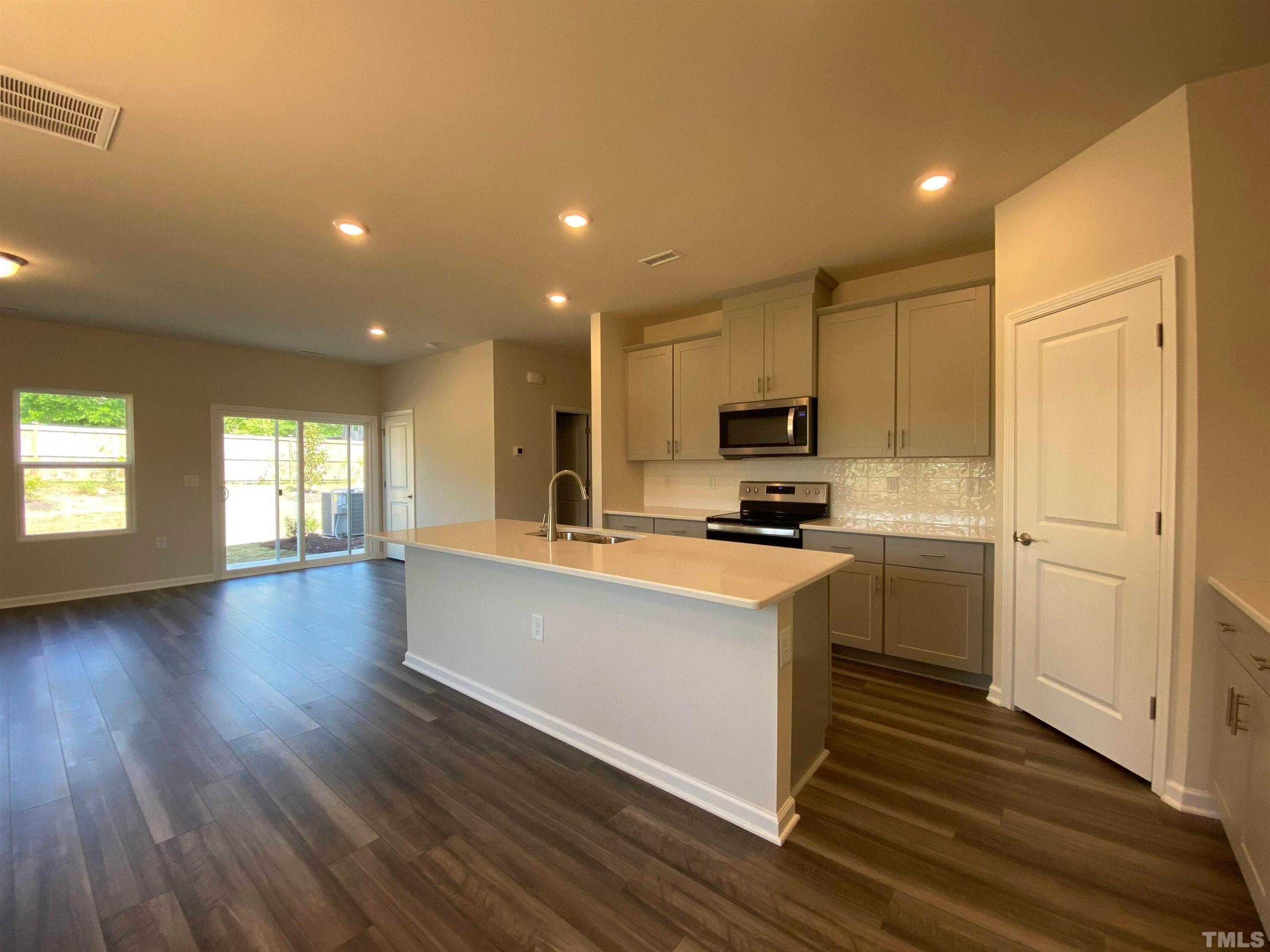 908 Clearhaven Lane Fuquay-Varina, NC 27526 - Photo 14 of 23 a kitchen with stainless steel appliances granite countertop a stove a sink and a refrigerator