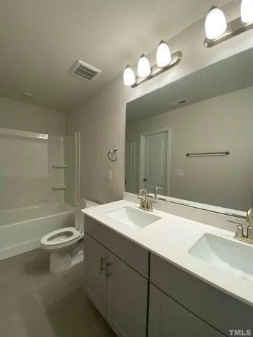 a bathroom with a sink a toilet and a large mirror
