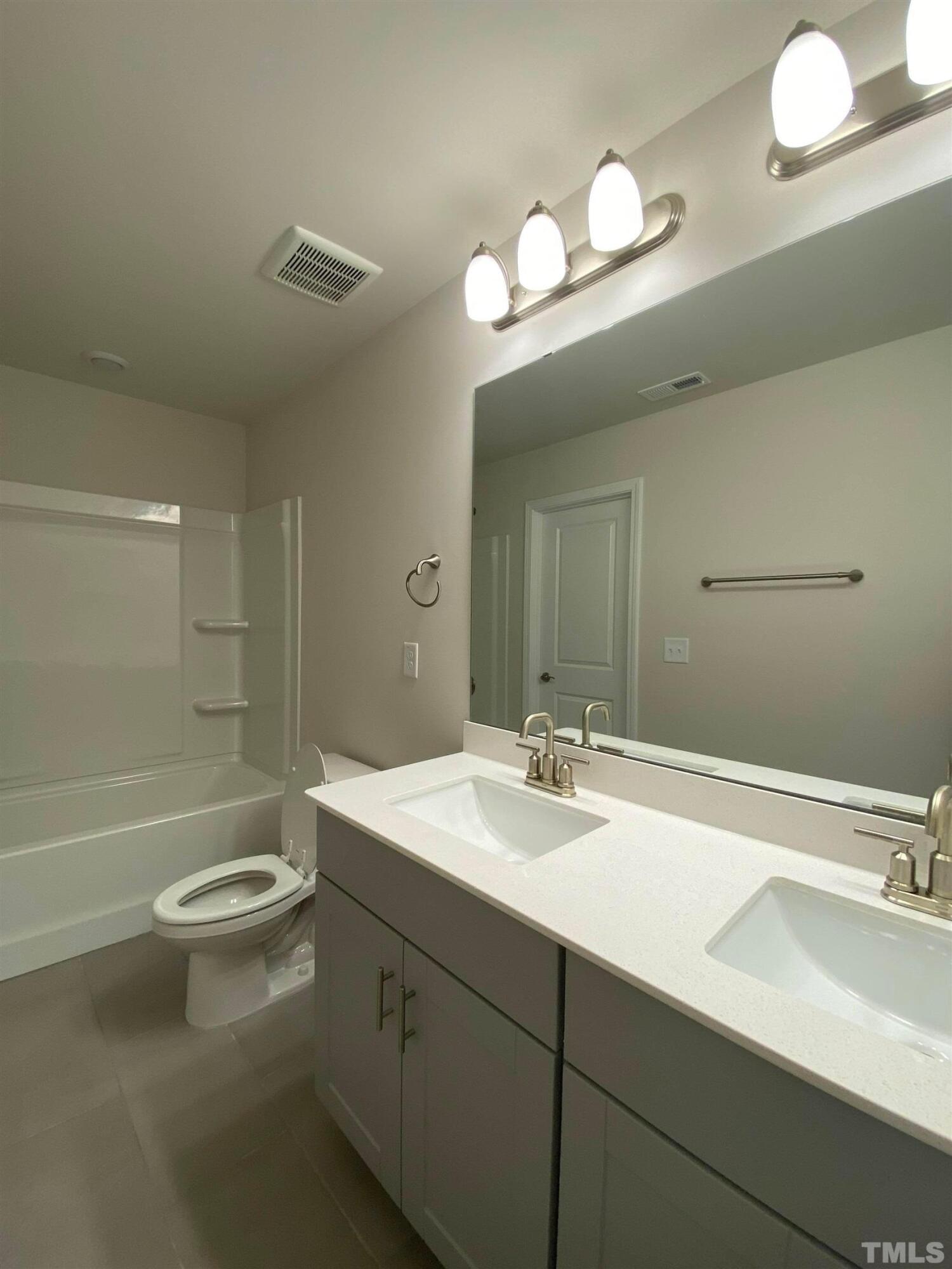 908 Clearhaven Lane Fuquay-Varina, NC 27526 - Photo 23 of 23 a bathroom with a sink a toilet and a large mirror